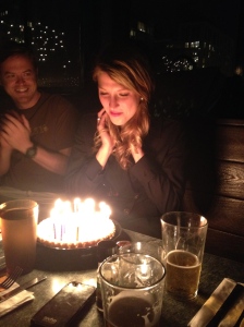 Jenna Dagenhart prepares to blow out her birthday candles while John Ismay applauds.